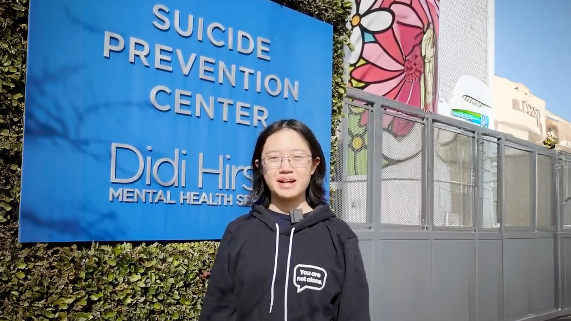 Sydney standing in front of Suicide Prevention Center sign.